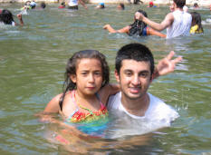 Shahryar Naqvi swims with a little girl from the orphanage