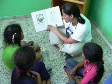 Lise Freking reads to the children after books were donated to the library