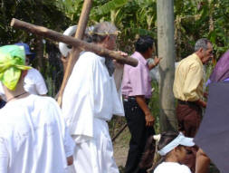Mike Ruhland carries the cross during Stations of the Cross on Good Friday
