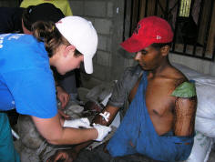 Nurse Tasha Wernimont begins an IV on an injured man