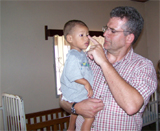 Fr. Kevin Richter holds child from Sulaco Malnutrition Center