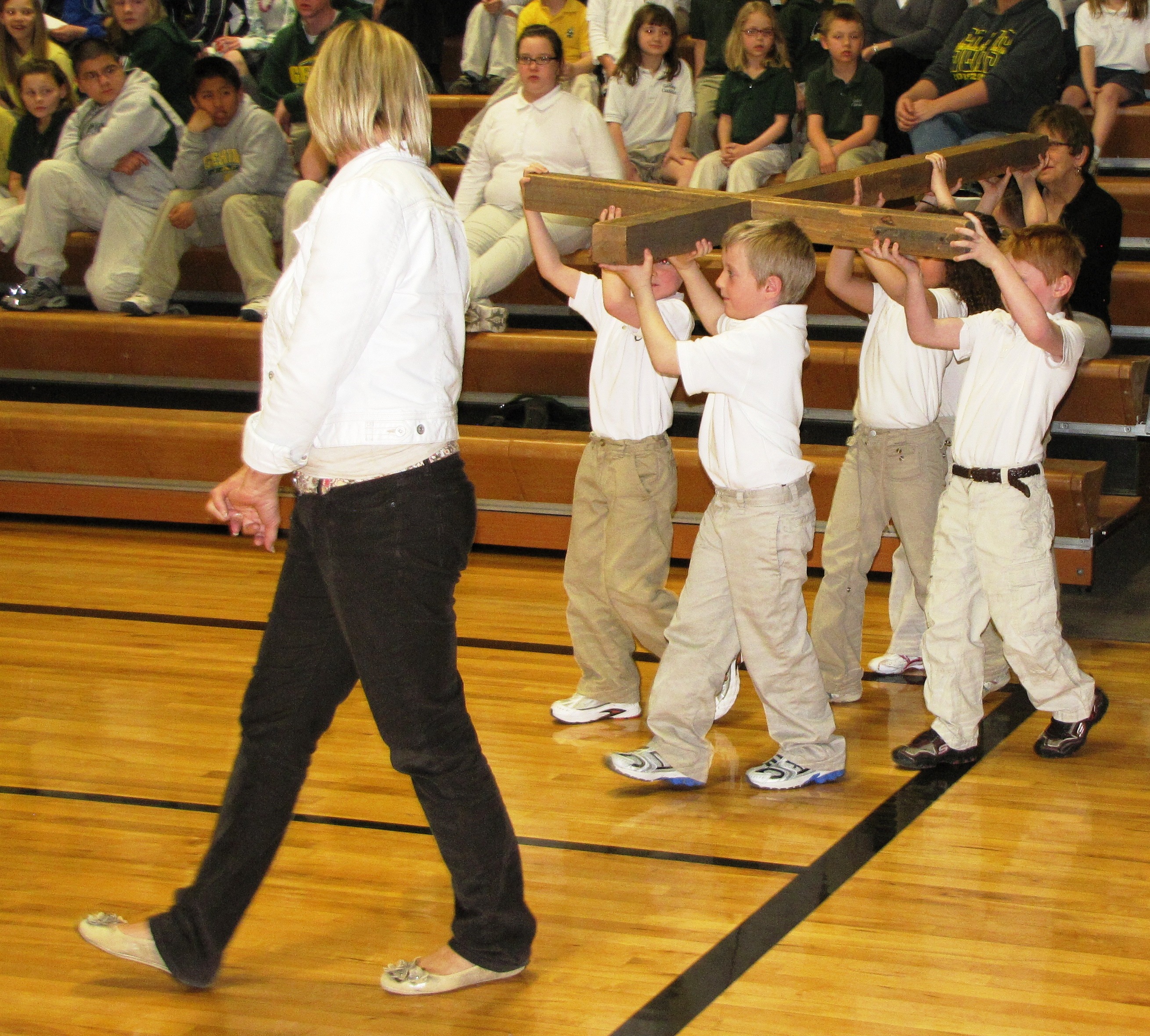 Kindergarten students carry cross