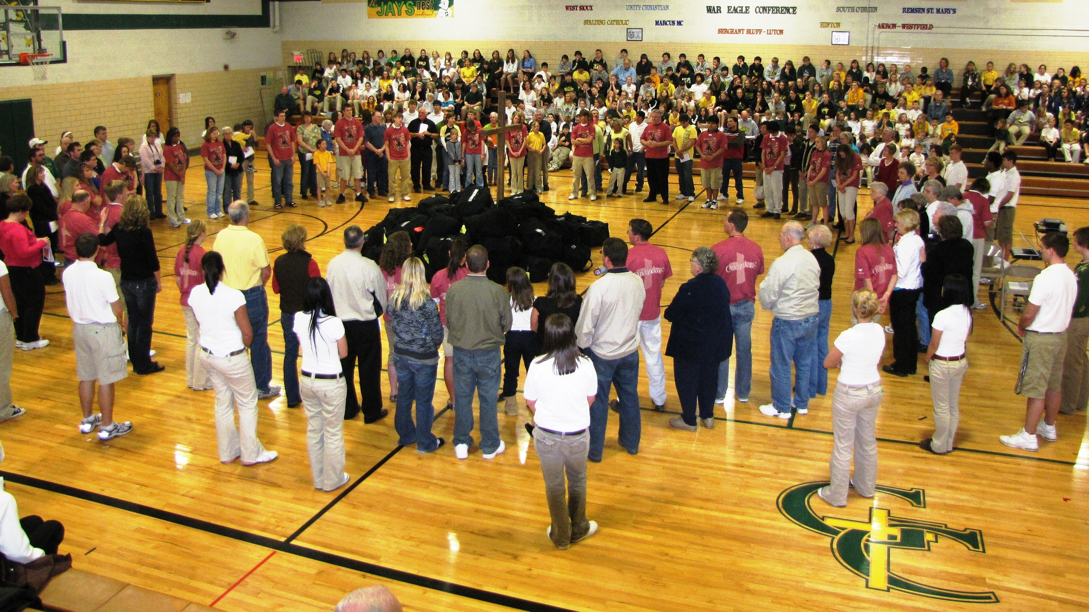 Missioners, family, & friends surround cross and bags during Send-Off