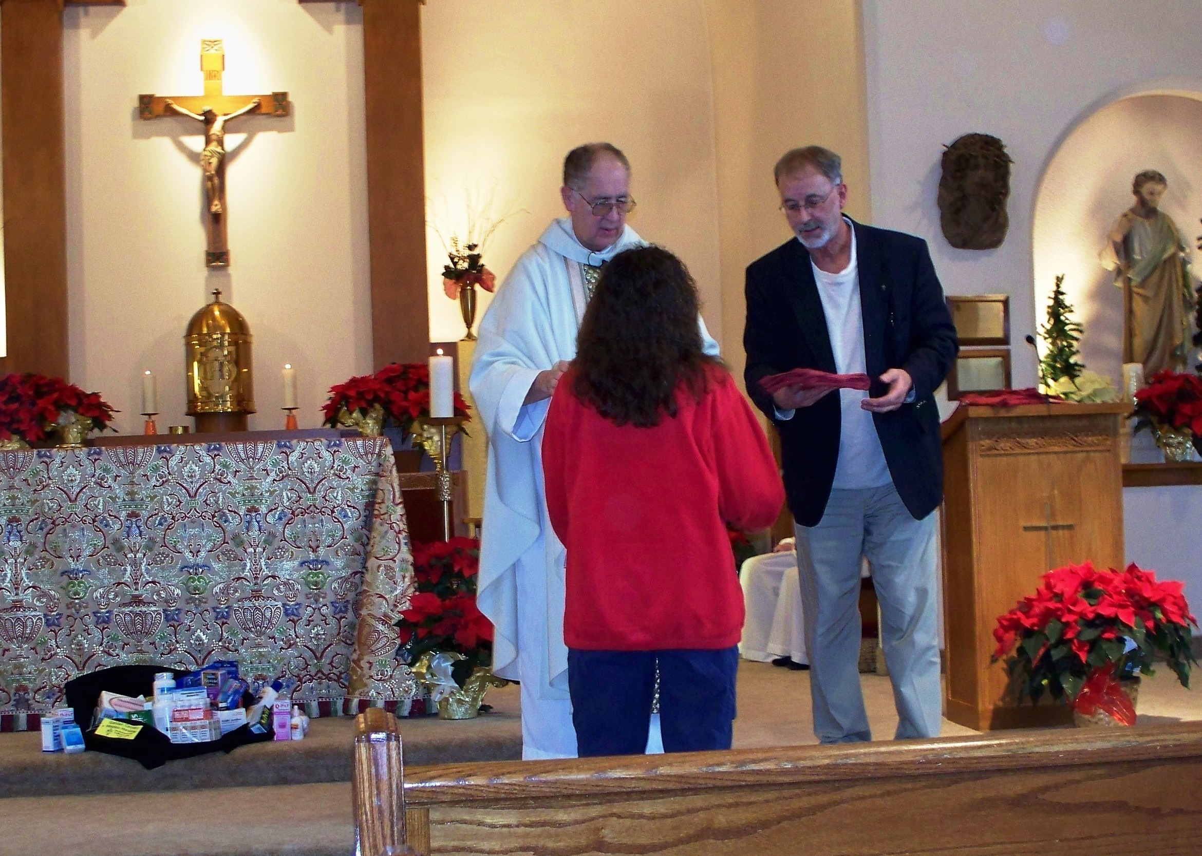 Med Team member receives cross and shirt during Mass