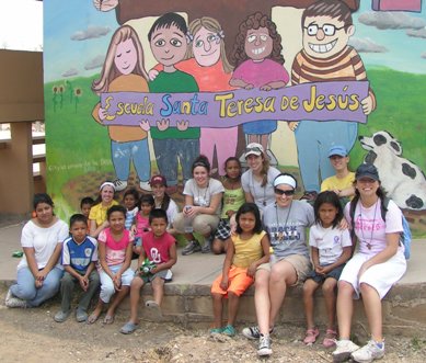 Missioners pose with students from St. Teresa of Jesus School in New Capital